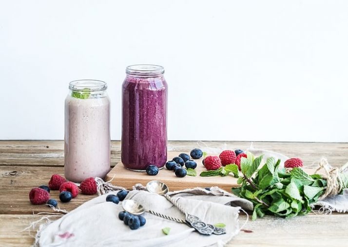 The Ugly TRUTH About Meal Replacement Shakes; Fresh healthy smoothie with blueberries, raspberries in glass jars and mint