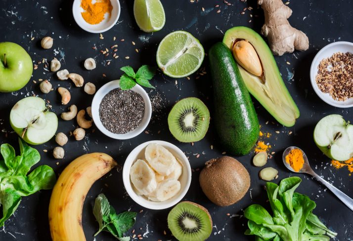 Green smoothie ingredients. Cooking healthy detox smoothies. On a dark background, top view