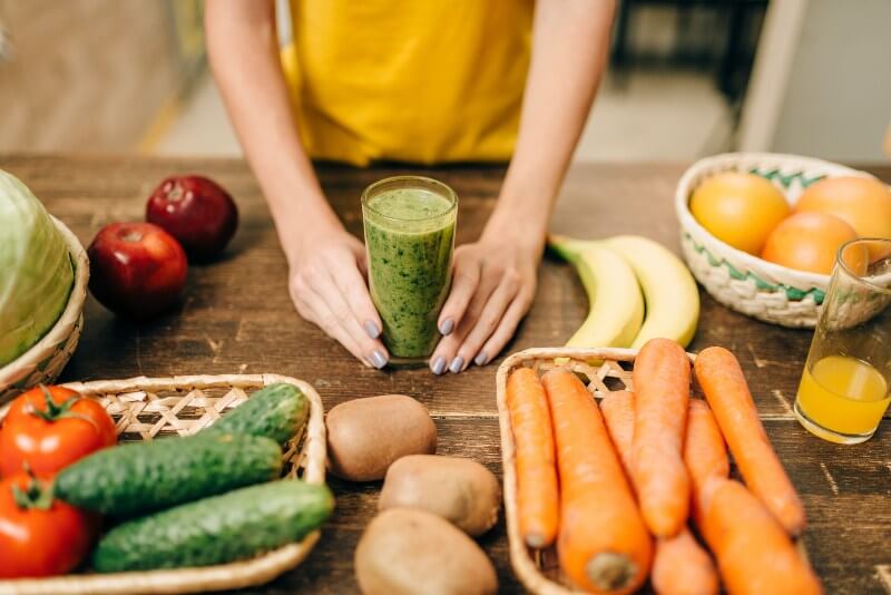 Going Vegan?; Female hands with cocktail of fruit and vegetables, green smoothie