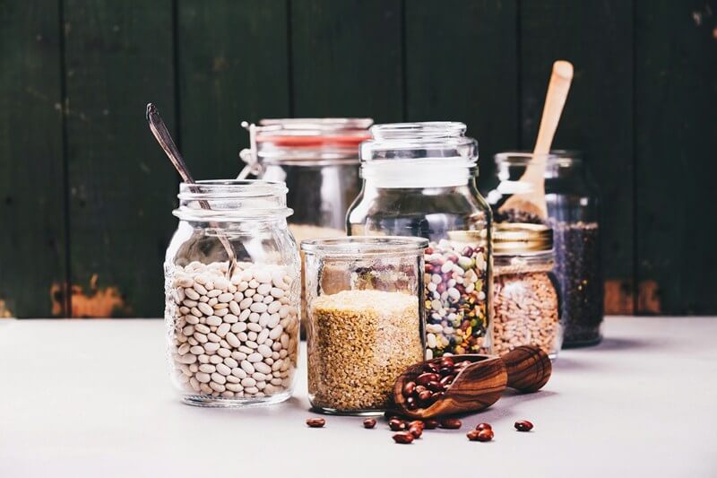 Paleo vs Vegan? Why A Pegan Diet Is Your Best Option; Glass jars with various legumes and grains