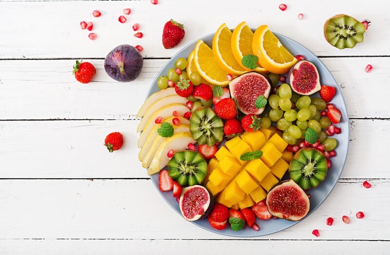 Paleo vs Vegan? Why A Pegan Diet Is Your Best Option; Platter fruits and berries, kiwis, mango, figs, berries, grapes, citrus