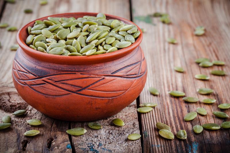 200+ Smoothie Ingredients Shopping List Printable; organic pumpkin seeds in a clay bowl on wooden rustic background