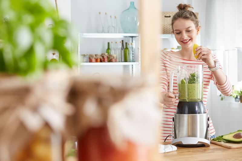 3 Vegetables That Provide ALL Your Essential Nutrients (With Only 450 Calories); Woman making vegetable green smoothie in a blender