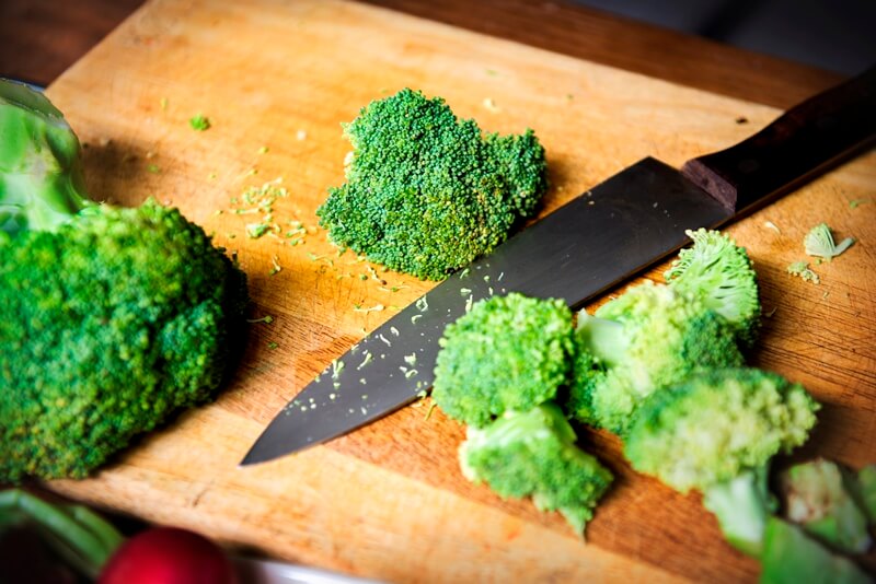 34 High Protein Vegetables You Probably Already Eat; cut fresh broccoli on cutboard