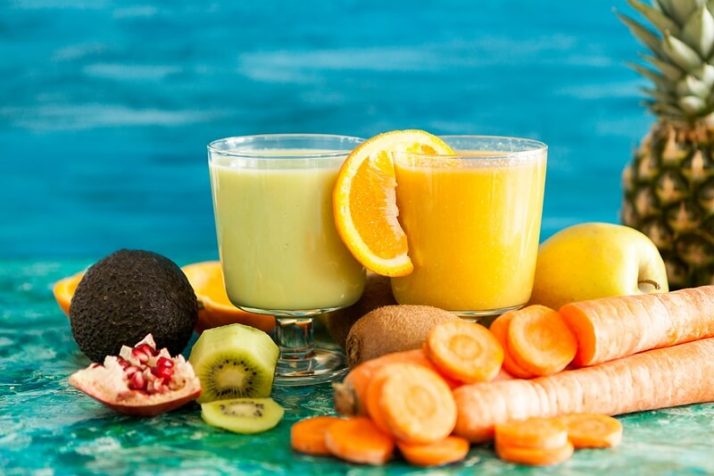 13 Reasons Why You Need Nutrition Drinks And Shakes In Your Life; two glasses with detox smoothies with carrot, orange, pomegranate, kiwi and avocado, pineapple