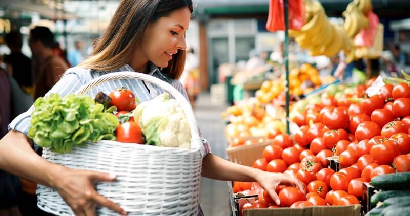 34 High Protein Vegetables You Probably Already Eat; woman at marketplace buying vegetables