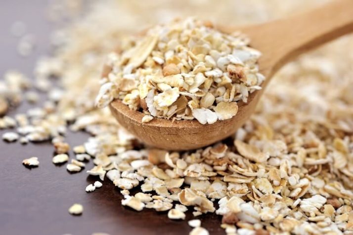 20 Ingenious Ways To Make Green Smoothies More Filling; Oat flakes on a wooden spoon