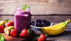 Blueberry smoothies on a wooden background with fruits. Vitamins