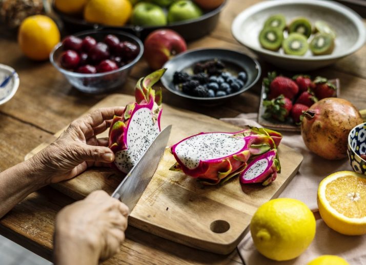 Guide To Fruit: Facts, Benefits, Tutorials, Recipes & Videos; Closeup of hand with knife cutting dragon fruit