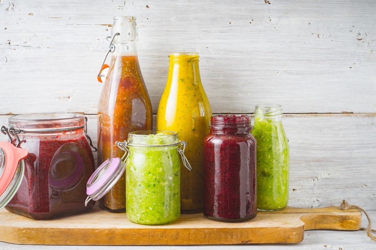 Smoothie Bottles and jar with different smoothie on the wooden board horizontal