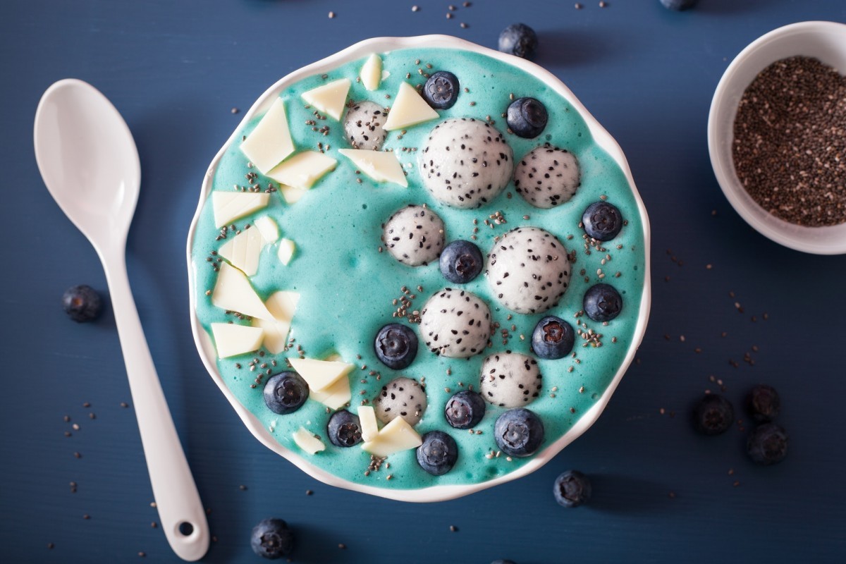healthy blue spirulina smoothie bowl with blueberry, white choco