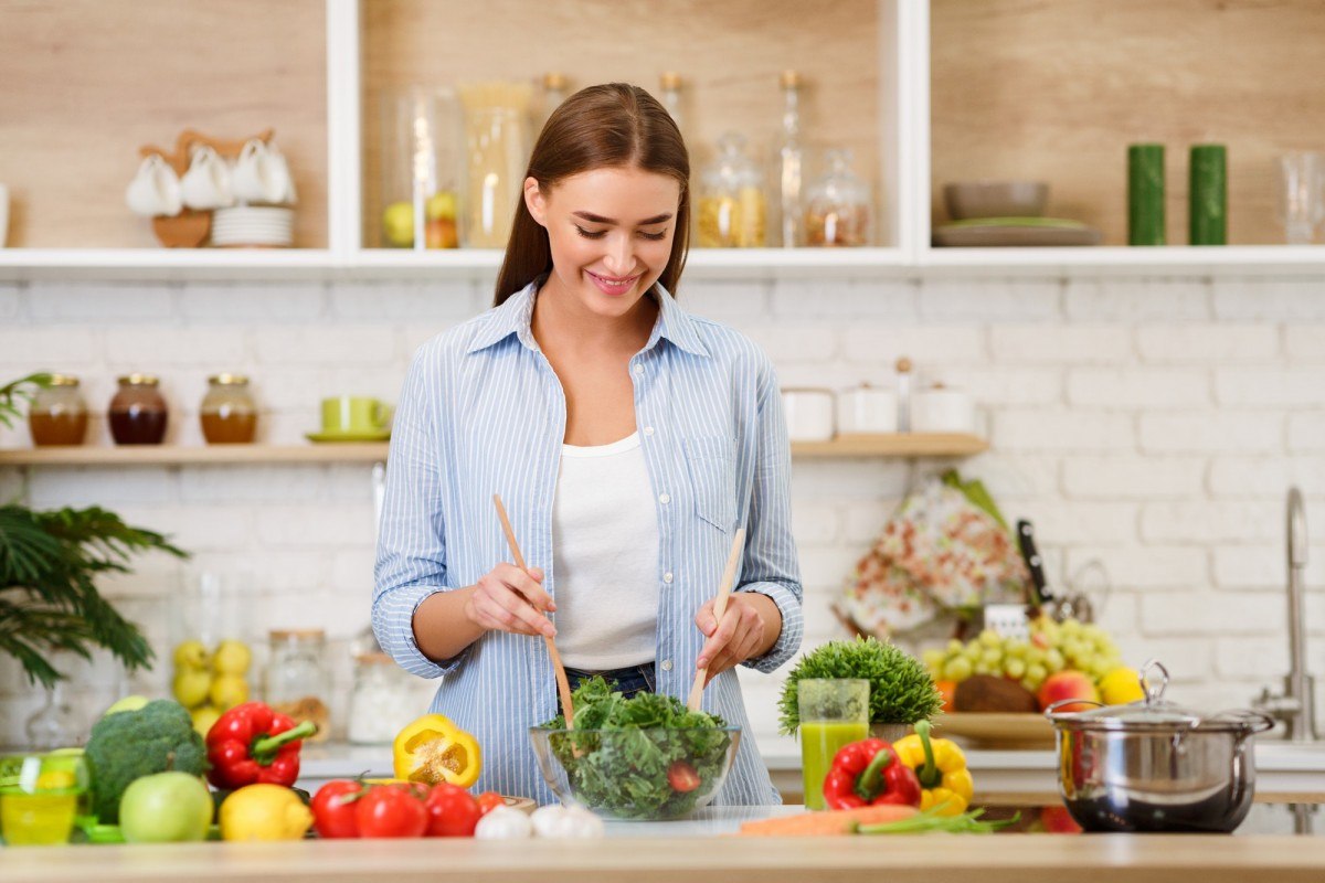 3 Vegetables That Provide ALL Your Essential Nutrients (With Only 450 Calories); Healthy Eating. Woman Mixing Fresh Salad In Kitchen